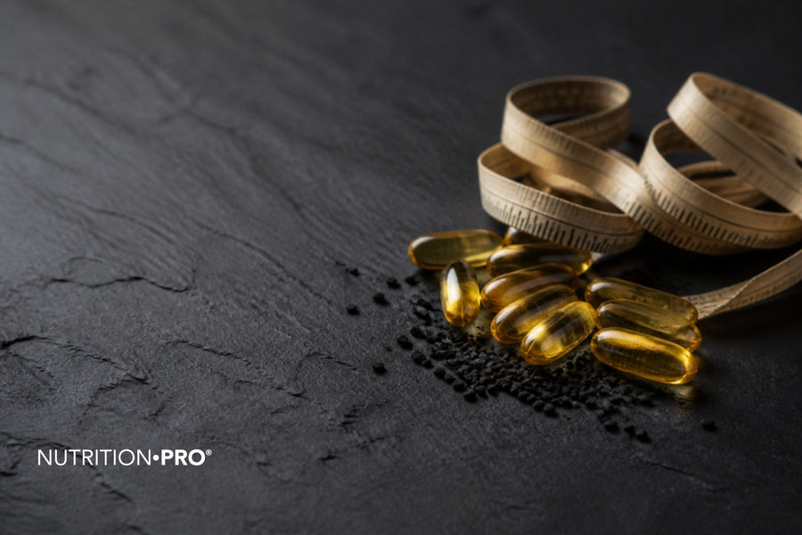 Capsules d huile de nigelle et ruban de mesure sur une ardoise sombre, nigelle et perte de poids