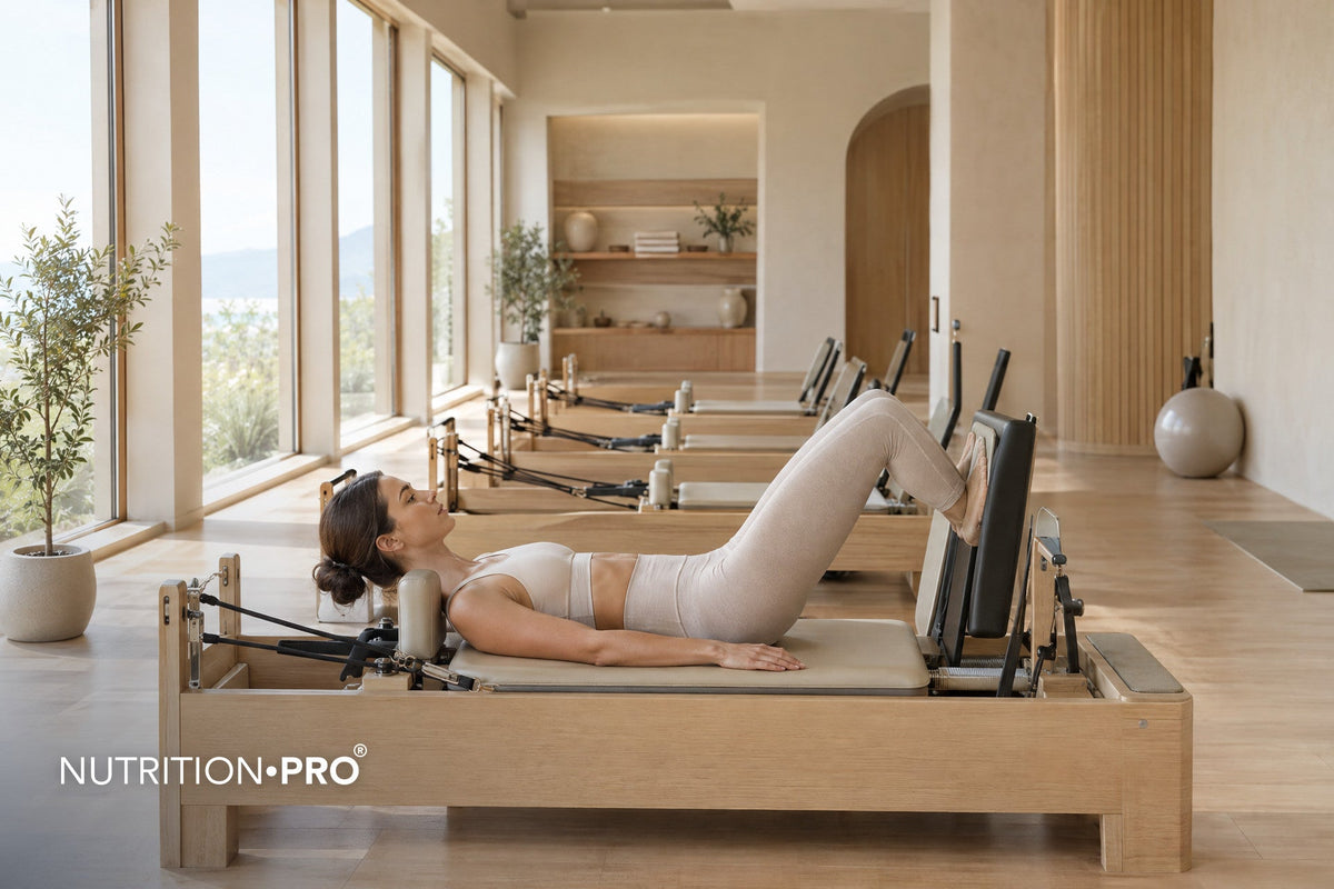 Femme qui s'entraîne sur un reformer dans un studio de Pilates lumineux